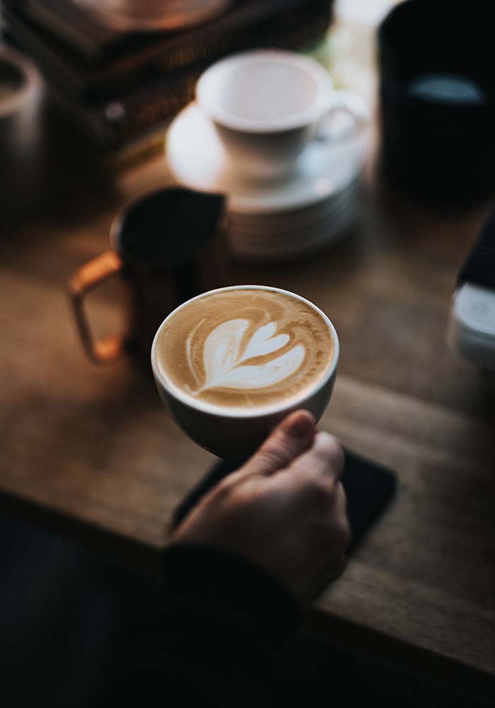 Person hält eine Tasse mit Kaffee